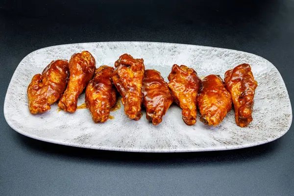 Siyah arka planda barbekü soslu tavuk kanadı kompozisyonu