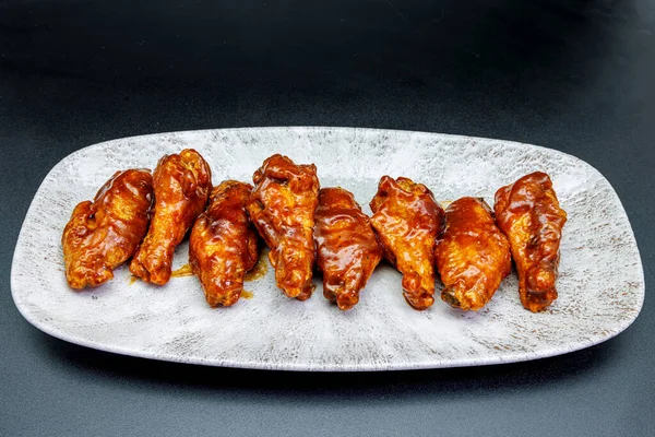 Siyah arka planda barbekü soslu tavuk kanadı kompozisyonu