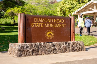 Honolulu, Hawaii - December 27, 2022:  tourists at the Diamond Head entrance sign at the Diamond Head State Monument.