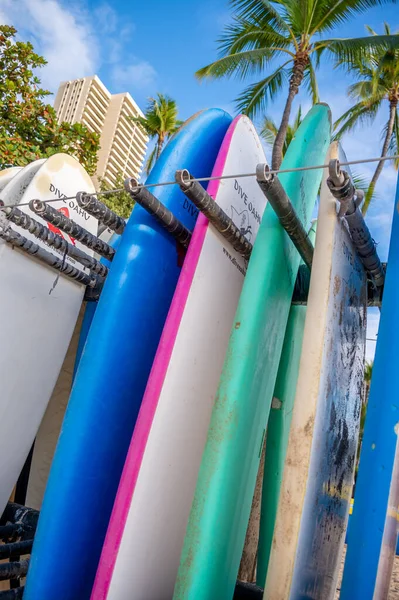 ハワイ州ホノルル 2022年12月29日 ワイキキビーチにあるビーチレンタルショップのラックに立つオアフ島のサーフボードをダイブ — ストック写真