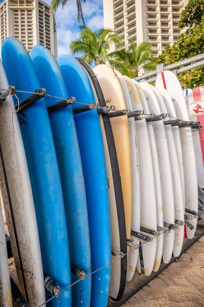 ハワイ州ホノルル 2022年12月29日 ワイキキビーチにあるビーチレンタルショップのラックに立つオアフ島のサーフボードをダイブ — ストック写真