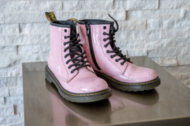 Calgary, Alberta - January 29, 2023: Pink patent leather Dr. Martens kids boots. clipart