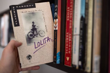 Calgary, Alberta - 16 Şubat 2024: Nabokov 'un Lolita adlı romanını bir kitaplıktan çıkarmak.