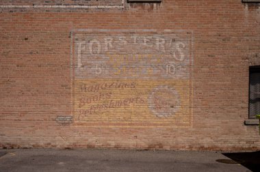 Fort MacLeod, Alberta - March 31, 2024: Vintage painted sign on a brick wall in Fort MacLeod Alberta. clipart