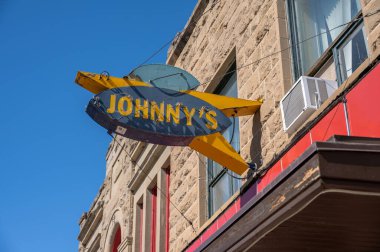 Fort MacLeod, Alberta - March 31, 2024: Vintage neon sign on Johnny's Restaurant in Fort MacLeod Alberta. clipart