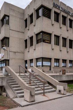 Calgary, Alberta - May 4, 2024: Former home of the Calgary Catholic School Board, this brutalist building now houses a health clinic and Bow Valley College facilities. clipart