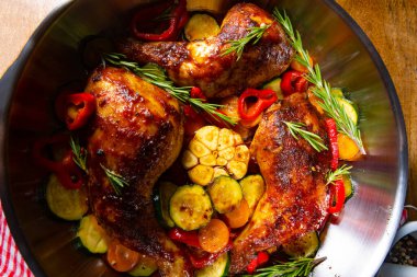 Çeşitli sebze ve baharatlarla kızarmış tavuk bacağı.