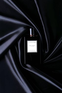 Parfüm şişesi .van cleef & arpels ambre embre siyah, ipek arkaplan düz yatar ve üst görünüm kopyala.