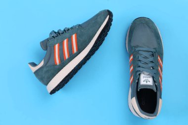 Jeddah, Suudi Arabistan - 25 Temmuz 2020: ADIDAS spor ayakkabısı, mavi arka planda. Ürün çekimi. Adidas spor ayakkabıları, giysileri ve aksesuarları tasarlayan ve üreten bir Alman şirketidir.