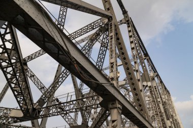 Hooghly nehri üzerindeki tarihi Cantilever köprüsü alacakaranlık gökyüzü ile. Howrah Köprüsü Hindistan 'ın en işlek köprüsü olarak kabul edilir..