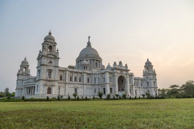 Kolkata 'nın göbeğinde, gündoğumu sırasında büyük mermer bir bina olan Bahçeli Victoria Anıtı' nın manzarası.