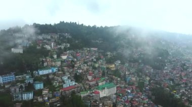 Batı Bengal, Hindistan 'da bulutlu bir günde Himalayalar' daki bir dağın yamacındaki Darjeeling şehrinin hava manzarası.. 
