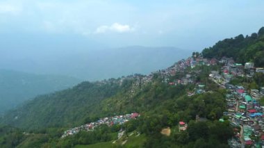 Batı Bengal, Hindistan 'da bulutlu bir günde Himalayalar' daki bir dağın üzerinden geçen Darjeeling şehrinin hava manzarası.. 