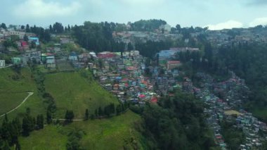 Batı Bengal, Hindistan 'da bulutlu bir günde Himalayalar' daki bir dağın üzerinden geçen Darjeeling şehrinin hava manzarası.. 
