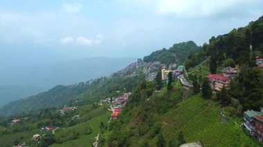 Batı Bengal, Hindistan 'da bulutlu bir günde Himalayalar' daki bir dağın üzerinden geçen Darjeeling şehrinin hava manzarası.. 