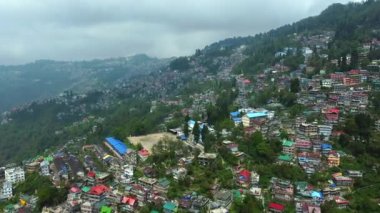 Batı Bengal, Hindistan 'da bulutlu bir günde Himalayalar' daki bir dağın üzerinden geçen Darjeeling şehrinin hava manzarası.. 