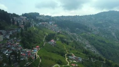 Batı Bengal, Hindistan 'da bulutlu bir günde Himalayalar' daki bir dağın üzerinden geçen Darjeeling şehrinin hava manzarası.. 