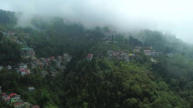 Batı Bengal, Hindistan 'da bulutlu bir günde Himalayalar' daki bir dağın üzerinden geçen Darjeeling şehrinin hava manzarası.. 