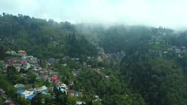Batı Bengal, Hindistan 'da bulutlu bir günde Himalayalar' daki bir dağın üzerinden geçen Darjeeling şehrinin hava manzarası.. 