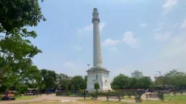 Kolkata, Batı Bengal, Hindistan 11 Nisan 2022 Shaheed Minar, Kolkata 'daki tugay sahalarında yemyeşil çimenler ve yanından geçen bulutlu gökyüzü ile çevrili..