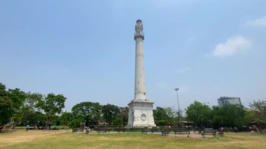 Kolkata, Batı Bengal, Hindistan 11 Nisan 2022 Shaheed Minar, Kolkata 'daki tugay sahalarında yemyeşil çimenler ve yanından geçen bulutlu gökyüzü ile çevrili..