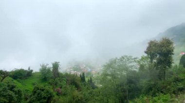 Batı Bengal, Hindistan 'da bulutlu bir günde Himalayalar' daki bir dağın tepesindeki Darjeeling şehrine bakın..
