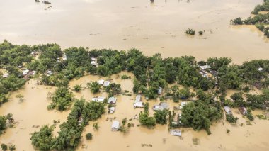19 Mayıs 2022 'de Silchar, Assam Hindistan Barak Nehri' nde küçük bir kasabanın havadan görünüşü su altında kaldı. Evler, doğa felaketi iklim değişikliği ile ilgili çamurlu su kavramını taşırdı..
