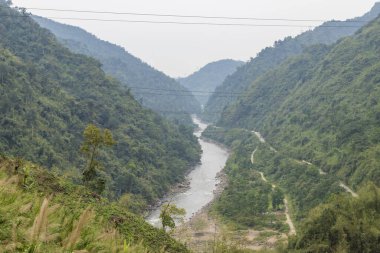 Hindistan 'ın kuzeydoğusundaki Arunachal Pradesh' in batısındaki sınır kasabası Bhalukpong yakınlarındaki yüksek dağların derin vadisindeki Kameng nehri manzarası..