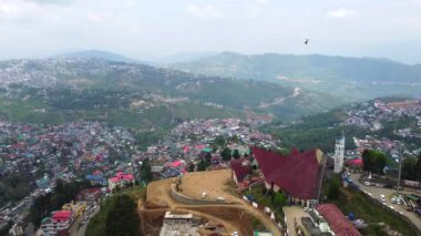 Kohima, Nagaland, Hindistan 'daki Kohima Katedrali boyunca binalarla ve Kohima Katedrali ile hava manzarası