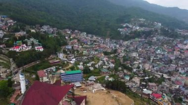 Kohima, Nagaland, Hindistan 'daki Kohima Katedrali boyunca binalarla ve Kohima Katedrali ile hava manzarası