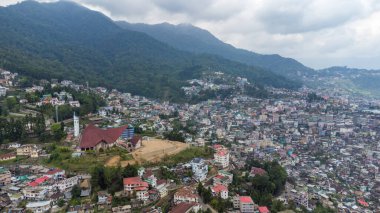 Kohima, Nagaland, Hindistan 'daki Kohima Katedrali boyunca binalarla ve Kohima Katedrali ile hava manzarası