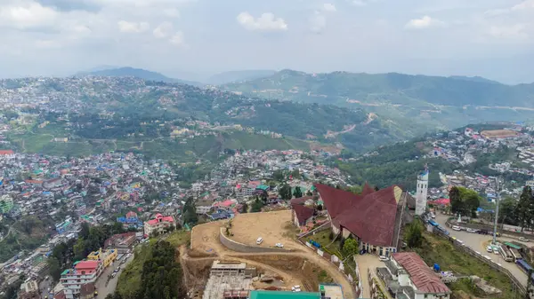 Kohima, Nagaland, Hindistan 'daki Kohima Katedrali boyunca binalarla ve Kohima Katedrali ile hava manzarası