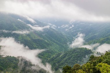 Dağlık vadi alçak bulutlarla dolu dramatik bir gökyüzü ile sabah görüntüsü Vah-Kabe Şelalesi 'nde alınır Cherrapunjee Meghalaya Hindistan.
