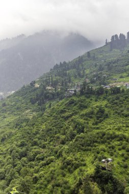 Small villages and colorful local houses nested in the hills of Parvati valley at manikaran, himachal pradesh, India. clipart