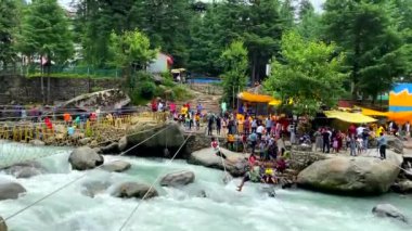 Manali, Himachal Pradesh, Hindistan, 2 Temmuz 2022. Manalis, Himachal Pradesh, Hindistan 'da Manalsu Nehri' ni geçen insanlar iple asılıyor.