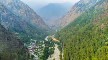 Aerial view of himalayan mountains at kasol himachal pradesh. Small villages and colorful local houses nested in the hills of parvati valley at kasol, himachal pradesh, India. clipart