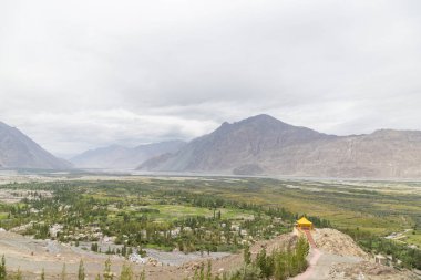 Diskit Manastırı 'ndaki renkli üç stupa, Nubra Vadisi' ndeki Diskit köyü manzaralı, Diskit, Ladakh, Hindistan