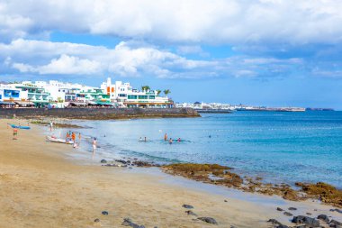 Playay Blanca, İspanya - 5 Nisan 2012: İnsanlar Playa Blanca, İspanya 'daki Playa Dorada plajının tadını çıkarıyorlar. Plaj 2010 yılında beyaz kumla restore edildi ve Lanzarote 'un en üst plajı oldu..