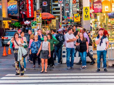 NEW YORK, USA  OCT 4, 2017:  people wait at a pedestrian crossing  at times square in late afternoon. Times square is a symbol for New York life and amusement.