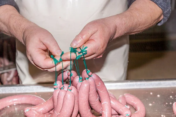 肉屋はドイツで乾燥するために調理されたソーセージを準備します — ストック写真