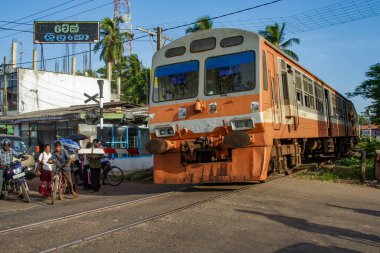 Colombo, Sri Lanka - 20 Ağustos 2005: İnsanlar Colombo 'daki eski dizel treni için açık bir demiryolu geçidinde bekliyorlar..