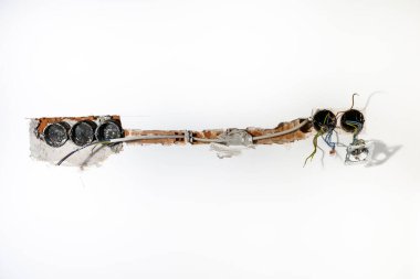 Beyaz duvarda, içi boş bir taşın içindeki kablo kanalı.