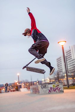 Wiesbaden, Almanya - 15 Aralık 2019: kaykay parkında scooterıyla atlayan çocuk.