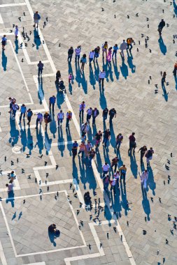 Venedik, İtalya - 11 Nisan 2007: San Marco meydanındaki turistler büyük güvercin sürülerini besliyor. San Marco Meydanı Venedik 'in en büyük ve en ünlü meydanıdır..