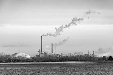 Geceyarısı Frankfurt 'ta tarlalar ve kışın tüten bacalarla sanayi kompleksi