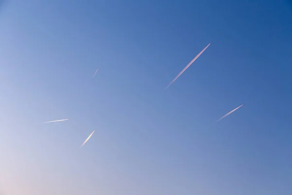 许多飞机在清晨阳光普照天空时留下的痕迹 — 图库照片