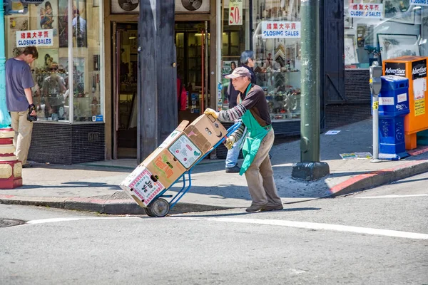 2008年7月24日 アメリカ サンフランシスコ市内の中華街をバックカートで貨物を運ぶ男と見る — ストック写真