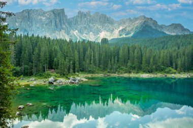 Carezza Gölü 'nün Panorama' sı, İtalya 'nın Güney Tyrol kentindeki Rosengarten sıradağları manzaralı Dolomitler' deki yüksek çam ormanlarıyla çevrili bir alp gölü.