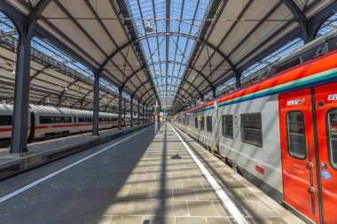 Wiesbaden, Almanya - 4 Nisan 2023: İnsanlar, Frankfurt Tren İstasyonu 'nun küçük bir kopyası olan Wiesbaden' deki klasik tren istasyonunda kalkış için tren istasyonunda bekliyorlar..