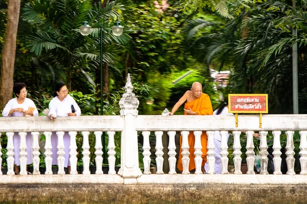 2007年12月26日 泰国曼谷 身穿白衣 身穿橙色僧袍的妇女向河里抛花 以纪念她们的虔诚 — 图库照片
